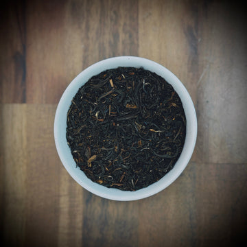 Close-up of freshly brewed Willow & Bloom Coffee on a wooden surface with aromatic steam.